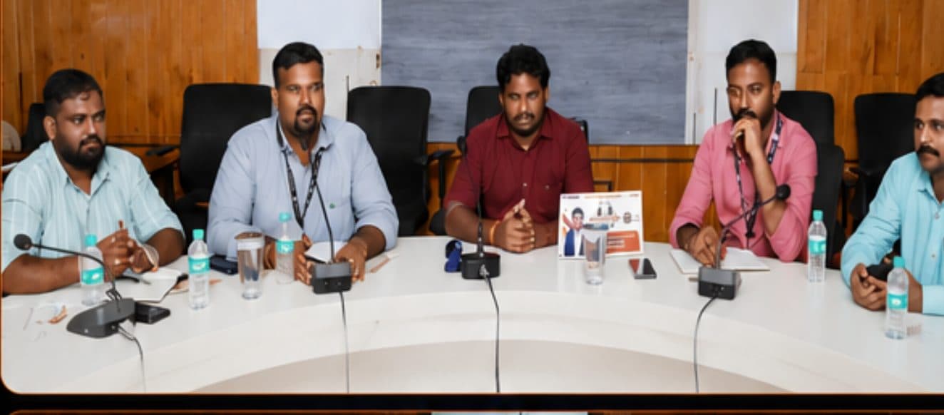 Panellists seated at a curved table with a small number of shared desk microphones during the Coffee with Collector startup interaction in Ramanathapuram